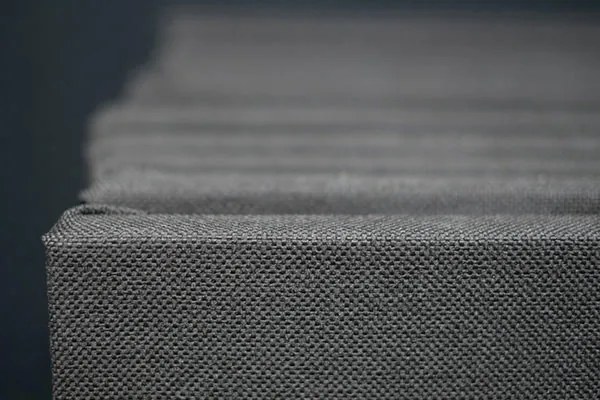 Close view of stacked CinemaBoards showing the woven fabric wrapped over a clean square edge, with no frame or trim
