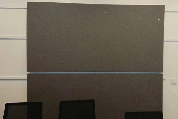 Two CinemaBoards mounted one above the other on a wall in a meeting room