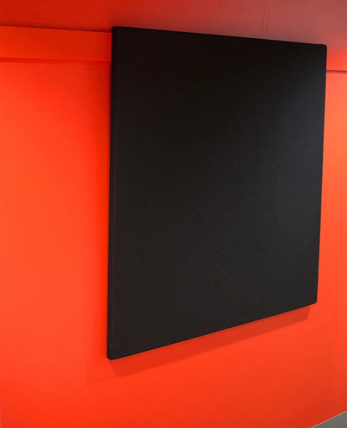 A borderless CinemaBoard in black fabric mounted on a studio wall, its fabric-wrapped edge standing slightly proud of the wall surface